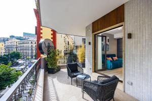 那不勒斯MH SUITES Plebiscito的大楼内的阳台配有椅子和沙发。