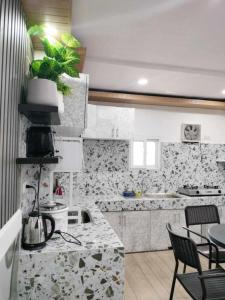 Una cocina con fregadero y una mesa con sillas. en Baguio transient house kalachuchi unit, en Baguio