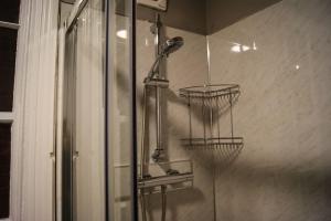 a shower with two wire baskets in a bathroom at Town Centre 2 Bedroom Apartment in Lincolnshire +18 photos