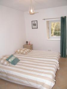 ein großes Bett in einem Schlafzimmer mit Fenster in der Unterkunft La Caz en Sol Charentais - Le Fâ in Montpellier-de-Médillan