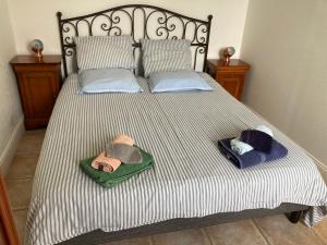 ein Bett mit zwei Hüten oben drauf in der Unterkunft La Caz en Sol Charentais - Le Fâ in Montpellier-de-Médillan + 8 Fotos