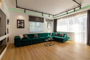 salon z zieloną kanapą i stołem w obiekcie HouseCube, Bar , prywatne Kino, Bilard , Luxus we Wrocławiu