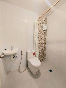 a white bathroom with a toilet and a sink at TRP4 - Rustic Styled 2BR Townhouse in DecaClark Angeles in Tacondo +20 photos