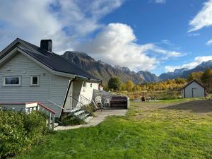 a house with mountains in the background of a field at Cozy small house with amazing view in Hennes