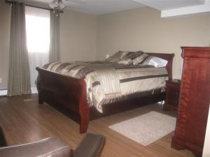 a bedroom with a large bed and a window at Driftwood Heights B&B in Summerside