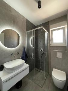 a bathroom with a shower and a toilet and a sink at Čiovo Bay Apartment in Slatine