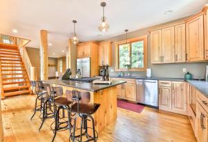 a kitchen with wooden cabinets and a island with bar stools at Luxurious Home & Amazing Views in Windham