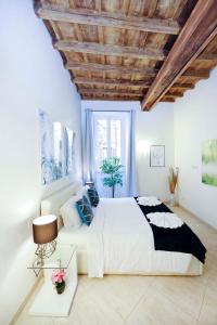 a bedroom with a large bed and a wooden ceiling at Mario Suite Spagna in Rome
