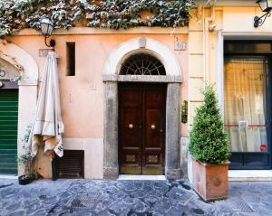a building with a door and a tree in front of it at Mario Suite Spagna in Rome