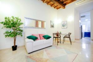 a living room with a white couch and a table at Mario Suite Spagna in Rome