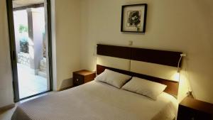 a bedroom with a white bed with a large window at Plakias Seaside Maisonette in Plakias +28 photos