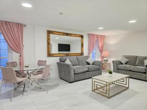 a living room with two couches and a table at Beautiful Cardiff Bay Apartment in Cardiff