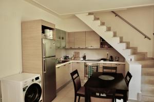 a kitchen and dining room with a table and a staircase at Plakias Seaside Maisonette in Plakias