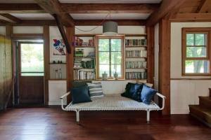 GilboaにあるPrivate Woodland Retreat with Cedar Hot Tub & Mt Viewのリビングルーム(ソファ、本棚付)