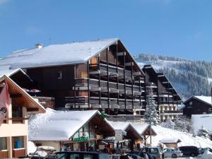 a large building with snow on the roof at Charmant 2 Pièces Cabine au Cœur des Saisies - Proche Pistes et Commerces - FR-1-293-1 in Les Saisies