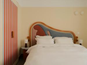 a bedroom with a large bed with white pillows at Edgar Suites Cannes - Rue d'Antibes in Cannes