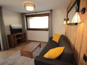 a living room with a couch and a tv at Charmant appartement neuf avec balcon, 2 chambres, 2 SDB et parking au cœur des Saisies - FR-1-293-272 in Hauteluce