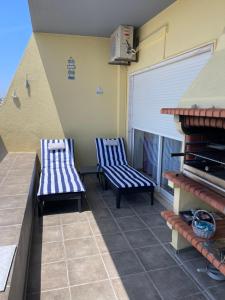 two blue chairs sitting on a balcony at Condominio do Mar in Lagos