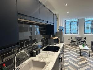 a kitchen with a sink and a counter top at City Centre Apartments - 1 Bed Apartments - 5 Min Walk from Train Station - Designed for Professionals - Free WiFi - Full Kitchen - Sofa Bed - Ideal for Long Work Stays in Peterborough +17 photos