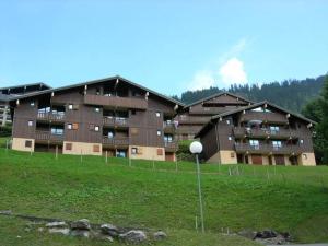ein großes Gebäude auf einem Feld neben einem Grasfeld in der Unterkunft Studio confortable à Châtel - 4 pers, balcon, parking et WiFi - FR-1-198-237 in Châtel