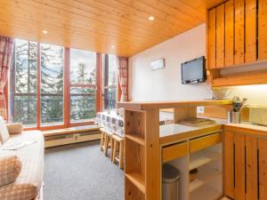 kuchnia z drewnianymi ścianami i oknami oraz kanapą w obiekcie Duplex rénové calme 6/7 pers. avec balcon - FR-1-346-332 w mieście Arc 1800