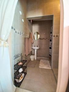 a bathroom with a sink and a toilet and a mirror at Sandy Pearl Cottage in Durban