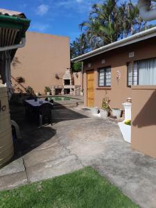 a backyard with a table and a house at Sandy Pearl Cottage in Durban +12 photos