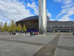 a large building with people walking in front of it at Beautiful Cardiff Bay Apartment in Cardiff