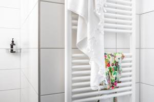 フリードリヒスハーフェンにあるBodenseeApartment Kammerのバスルームのタオル掛けに掛けられた白いタオル +2枚の写真