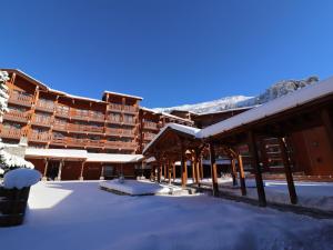 a large building with snow on the ground at Charmant 2 pièces cabine skis aux pieds, parking inclus - FR-1-182-245 in Les Allues