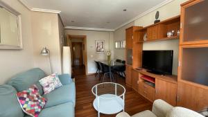 a living room with a blue couch and a television at Apartamento de Toró in Llanes