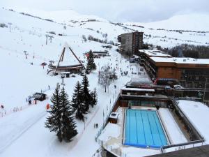 a ski resort with a swimming pool in the snow at Studio cosy skis aux pieds avec balcon et piscine chauffée - FR-1-267-205 in Le Corbier