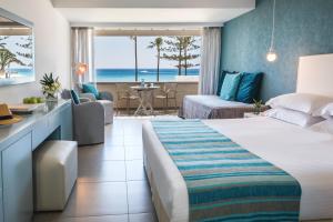 a hotel room with a bed and a view of the ocean at Nissi Beach Resort in Ayia Napa