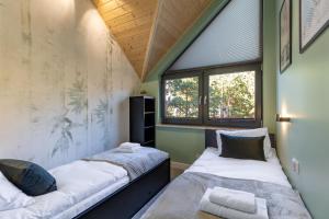 two beds in a room with two windows at Sosnowy Szum Sauna 3 Wanny Spa in Jastrzębia Góra