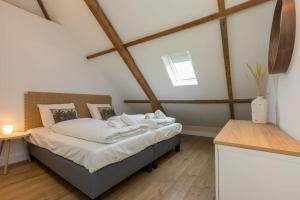 a bedroom with a bed in a room with wooden floors at Zuss & Sleep Koudekerke in Koudekerke