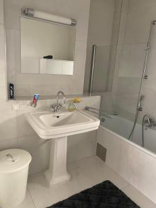 Un baño con lavabo, inodoro y ducha. en Pension Sanela, en Neunkirchen