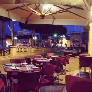 un restaurante con mesas y sillas en una calle por la noche en Peaceful & Modern Corner Apartment, en Qala