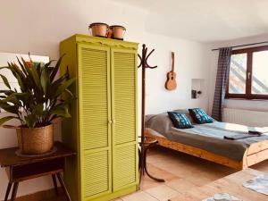 a bedroom with a yellow cabinet and a bed at Repülőhal Apartmanház in Zebegény