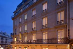 un grand bâtiment avec un panneau sur son côté dans l'établissement Le Petit Belloy, à Paris