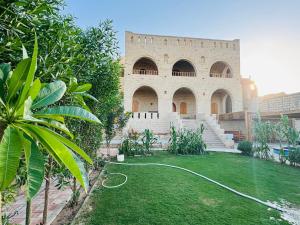 a building with a yard with a hose at Pidgeon Lodge - Tunis Village in Tunis