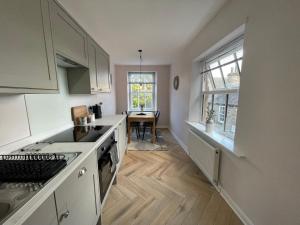 a kitchen with white cabinets and a table and a window at Castle View Apartments - The Hideout in Kendal