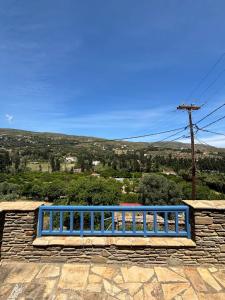 a blue bench sitting on top of a stone wall at Andros Guesthouses in Andros