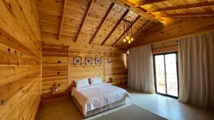 a bedroom with a bed in a wooden room at درة العروس اكواخ الدره in Durat Alarous +36 photos