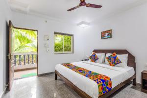 a bedroom with a bed and a window at FabHotel Raj Resort in Calangute