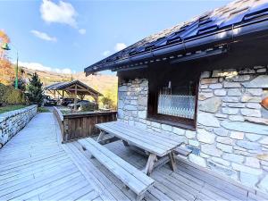a wooden bench sitting on a deck next to a building at Grand Appartement Confortable 10/12 Pers, Terrasse, Parking - FR-1-267-250 in Villarembert