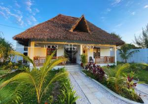 a hotel in a resort with a thatched roof at Villa Changarawe in Mdudu Mkubwa