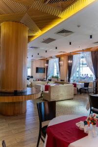 a restaurant with tables and chairs in a room at City Palace Hotel Tashkent in Tashkent