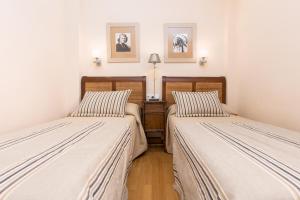 two beds in a room with white walls at 3BR Jandia House - Private Pool, Seaviews & Golf in Pájara