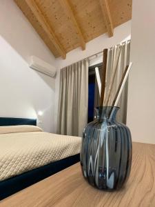 a large glass vase sitting on a table next to a bed at Cascina Ricardin in Coazzolo
