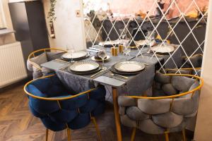 a table with chairs and plates on top of it at Royalty Apartment with City Views on Calea Victoriei in Bucharest
